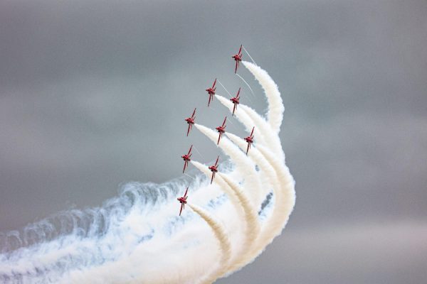 A group of red arrow planes soaring through the sky.