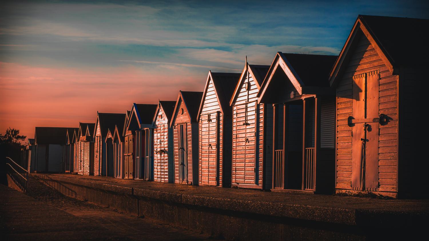 Atmospheric sunset lighting the beach huts along the North Sea Observatory in Chapel St Leonards.